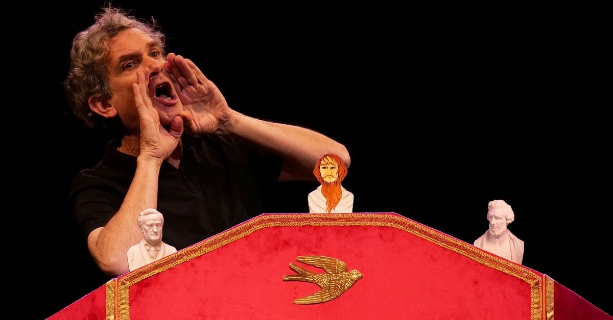 Derrière un castelet rouge, un comédien conte avec énergie l'univers de Wagner. Une image qui évoque un théâtre de récit, musical et plein d'humour.