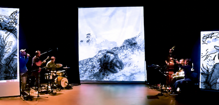 Une scène de spectacle plongée dans la pénombre, où plusieurs musiciens se produisent de part et d'autre de l'espace scénique. Trois grands écrans verticaux projettent des illustrations en noir et blanc, réalisées dans un style mêlant encre et aquarelle.